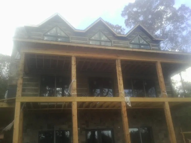 Dormers and porch framing on a large log home under construction — Roof Coating work by our crew in Wagener