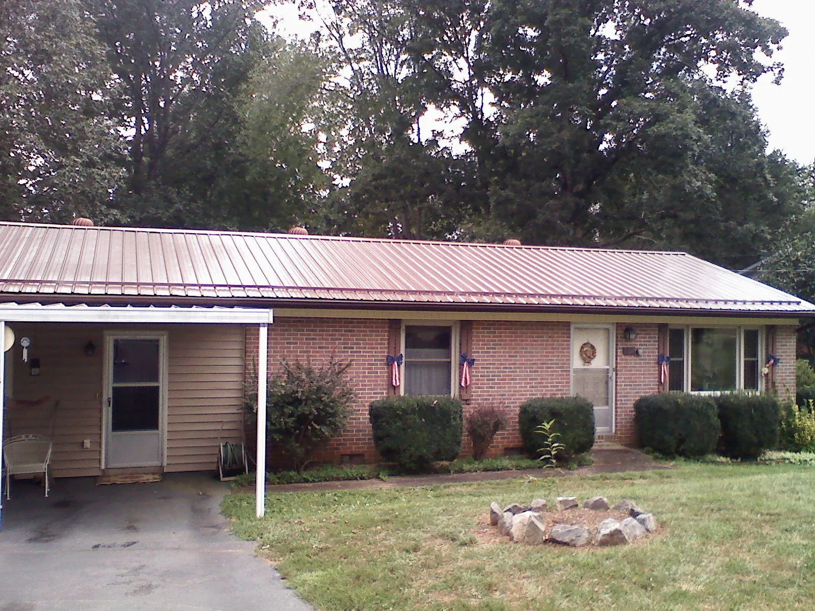 Bronze metal roof and carport on a brick ranch home — Roof Repair work by our crew in Wagener